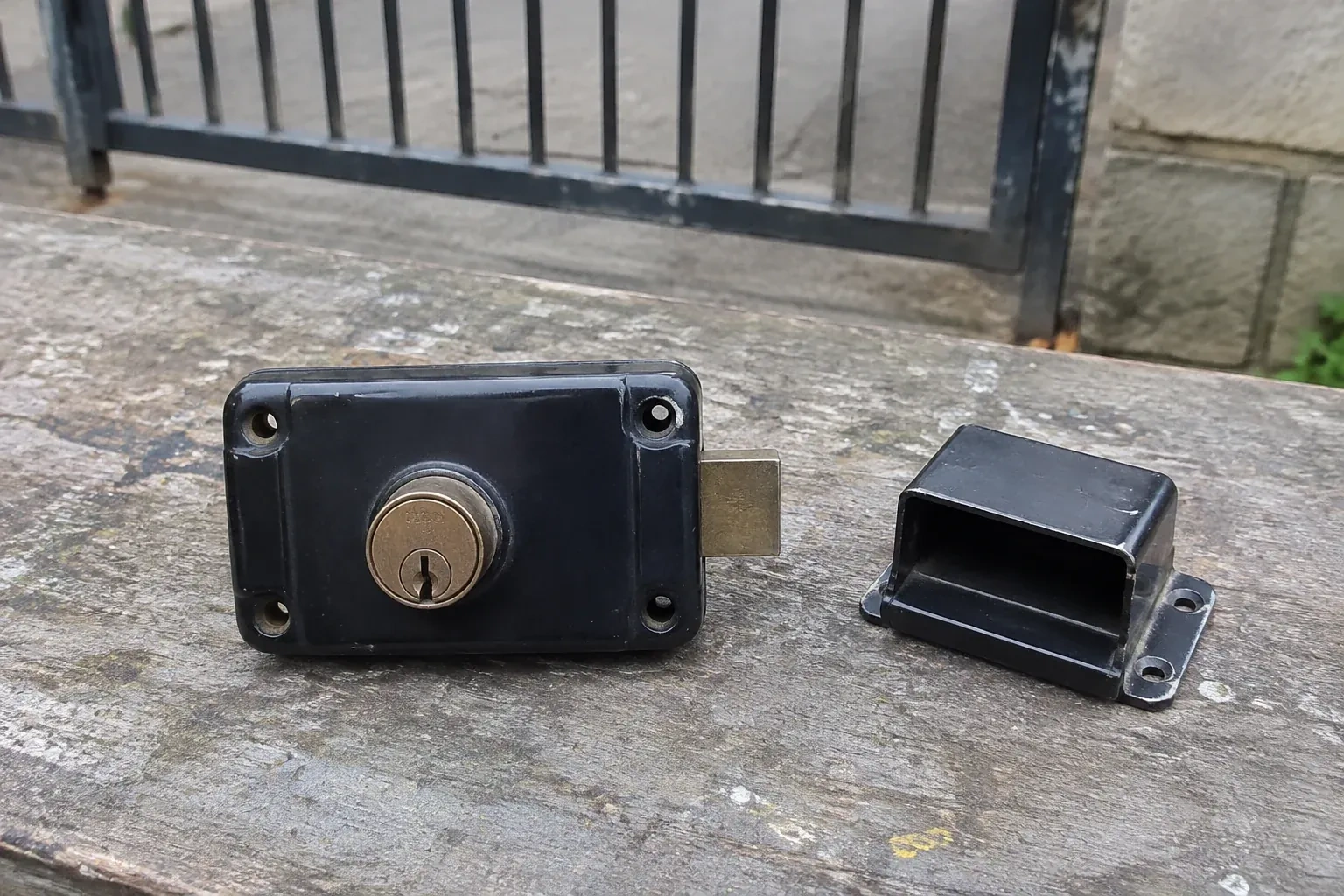 Detached rim gate lock and separate box keeper on an outdoor workbench. — Gate & Building Entry Locks, Peterborough